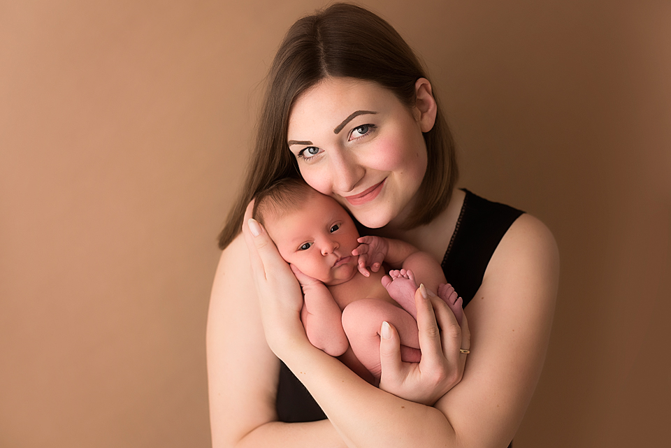 Portrait einer jungen Mutter mit neugeborenem Baby auf dem Arm  
