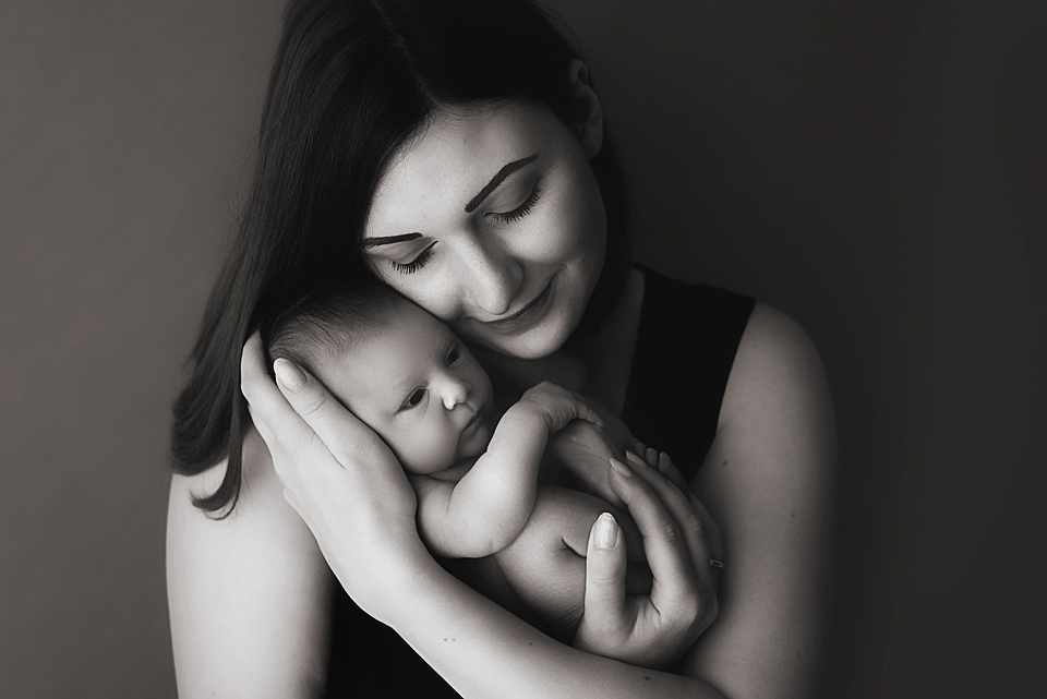 Portrait einer jungen Mutter mit neugeborenem Baby auf dem Arm  